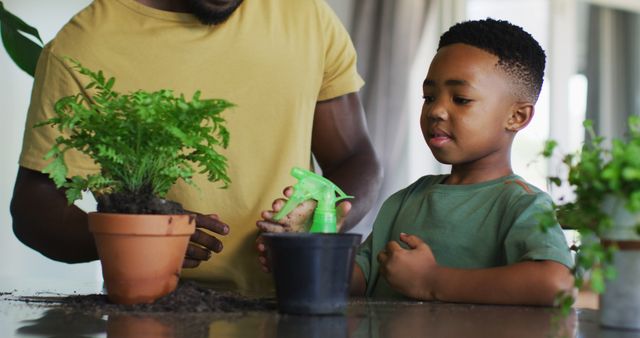 African American father teaching young son gardening indoors with potted plants. Use for topics on parenting, family activities, gardening tutorials, education, bonding moments, or green living.