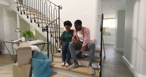 Happy Couple Unpacking and Enjoying Coffee in New Home