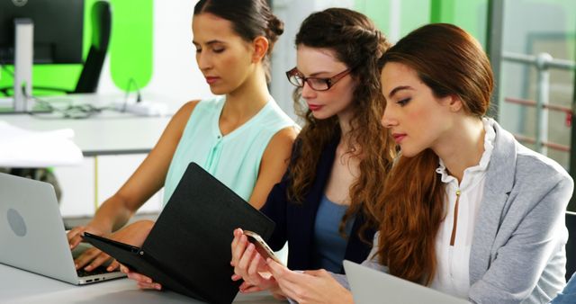 Focused Businesswomen Analyzing Data on Digital Devices in Office - Download Free Stock Images Pikwizard.com