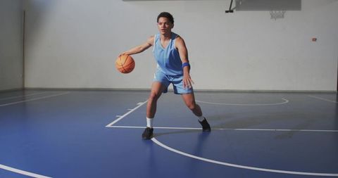Athlete Dribbling Basketball on Indoor Gym Court