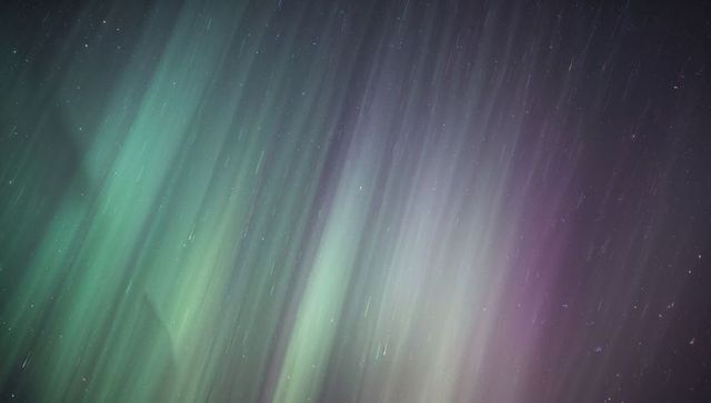 Dancing Northern Lights with Long-Exposure Star Trails in Green Teal and Purple Gradient