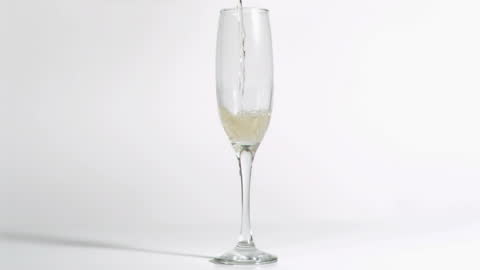 Pouring Champagne into Flute in Slow Motion on White