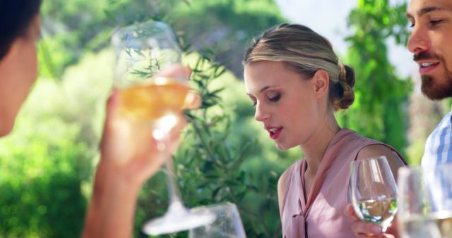 Friends Enjoying Wine Outdoors at Sunny Garden - Download Free Stock Images Pikwizard.com