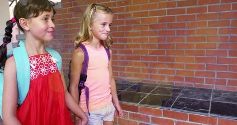 Happy Schoolgirls Walking Together with Backpacks