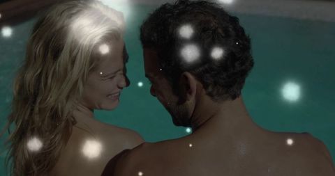 Smiling Couple Gazing Poolside with Ethereal Nighttime Glows