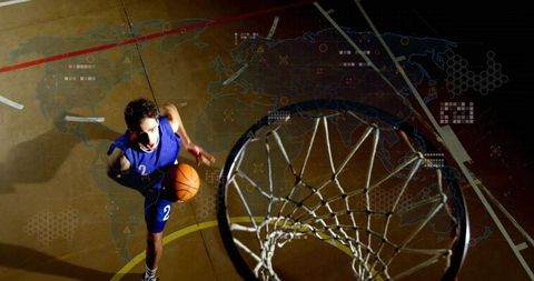 Leaping basketball player driving for dunk with digital world map overlays over court