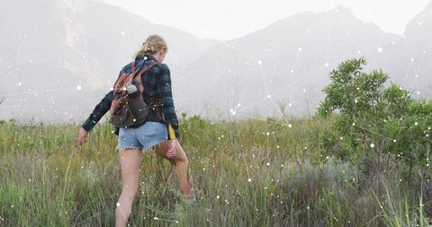 Woman Trekking Through Prairie Towards Misty Mountains, Adventure Awaits