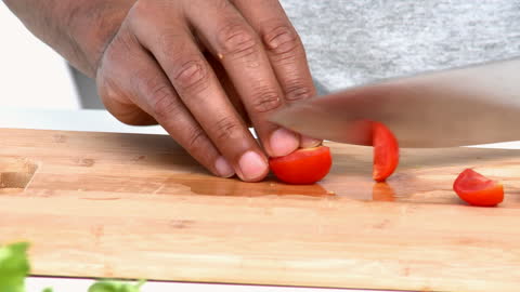 Chef's Hands Slicing Cherry Tomatoes on Cutting Board