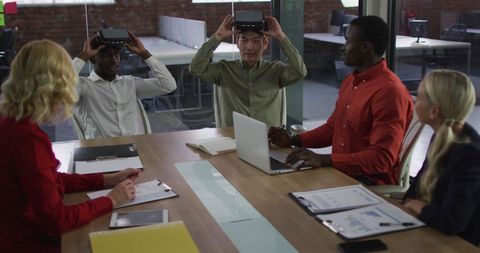 Diverse team experimenting with vr in modern office meeting