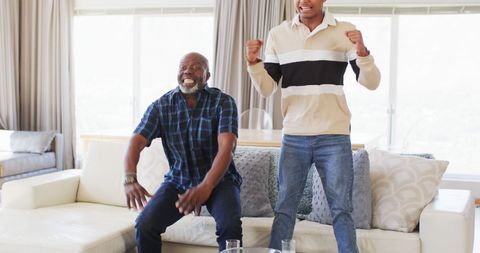 Father and Adult Son Celebrating Sports Victory at Home