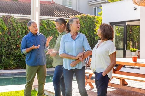 Senior friends socializing outdoors near pool area