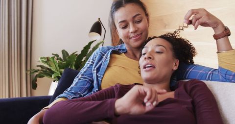 Happy Biracial Lesbian Couple Relaxing Together Indoors