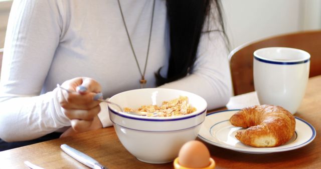 Close-Up of Woman Having Breakfast with Cereal and Croissant - Download Free Stock Images Pikwizard.com