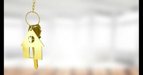 Gold House-Shaped Keychain in Bright Room for Real Estate Concepts