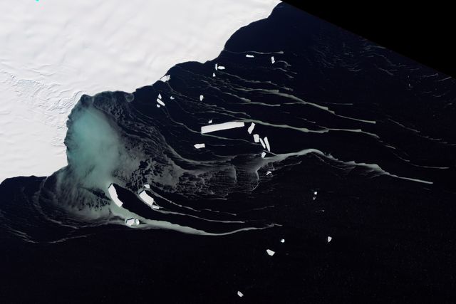 This satellite image from NASA’s EO-1 ALI shows Mackenzie Bay near the Amery Ice Shelf before northern icebergs, including ghostly blue-green tendrils possibly caused by frazil crystals. Suitable for use in scientific studies of glaciology and oceanography, as well as in educational materials discussing the effects of climate and oceanic processes in Antarctica. The image, captured in February 2012, is perfect for visually announcing research findings or featuring in news articles on polar regions.