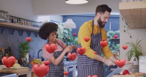 Happy Couple Cooking Together in Kitchen with Romantic Hearts Overlay