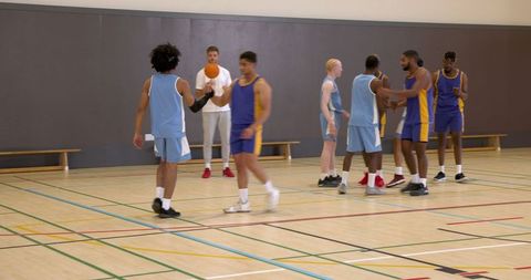 Diverse Basketball Team Practicing Indoors with Coach