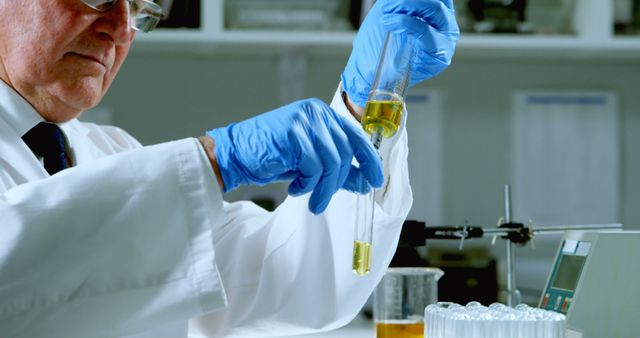 Scientist wearing lab coat and blue gloves conducting experiment with test tube in modern laboratory. Perfect for educational materials, scientific publications, research posters, and technology-related advertisements.