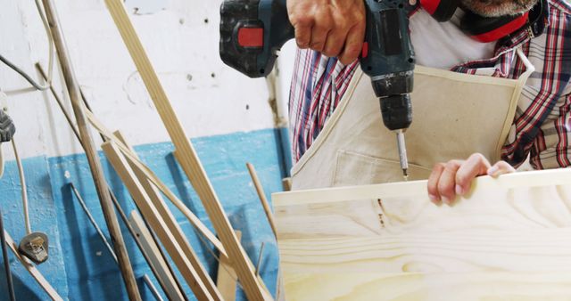 Carpenter Using Drill on Wooden Plank in Workshop - Download Free Stock Images Pikwizard.com