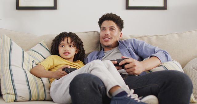 Happy biracial man and his son playing image games. domestic life, spending time at home.