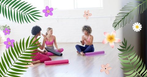 Women chatting with instructor after yoga class on pink and purple mats in bright studio