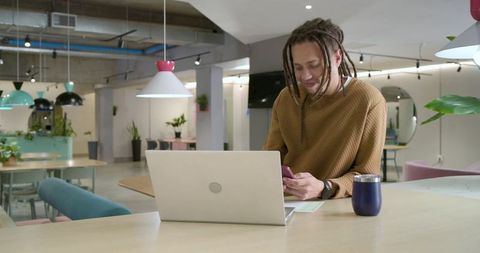 African American Freelancer Working Remotely in Modern Coworking Space with Laptop