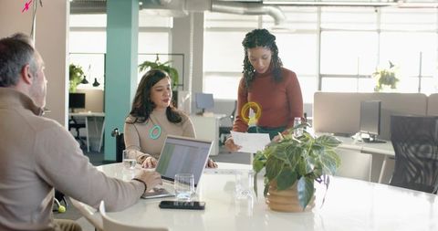 Reviewing documents during collaborative meeting at bright open-plan office table