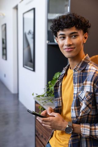 Modern office worker using smartphone in stylish corridor