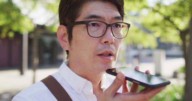 Close up of asian man talking on smartphone while standing on the street. business and lifestyle concept