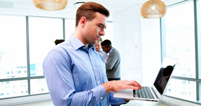 Focused Businessman Using Laptop in Modern Office Environment - Download Free Stock Images Pikwizard.com