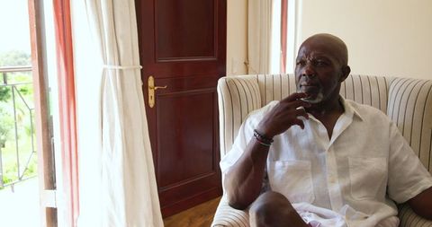 Elderly Man Reflecting Relaxed at Home with Balcony View