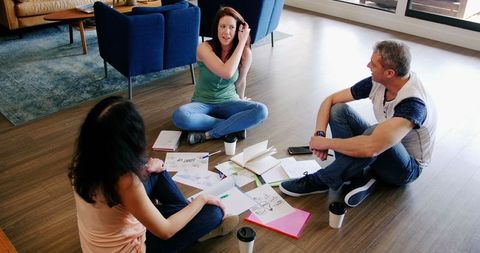 Caucasian Team Collaborating on Floor with Open Documents