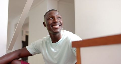 Smiling Man Sitting on Stairwell Serene and Relaxed