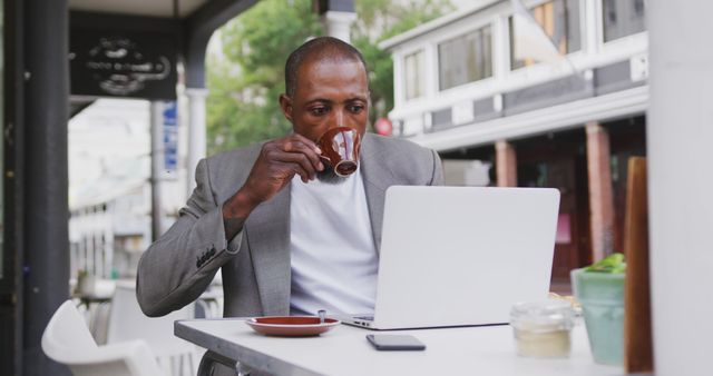 Businessman Drinking Coffee and Working on Laptop at Outdoor Cafe - Download Free Stock Images Pikwizard.com