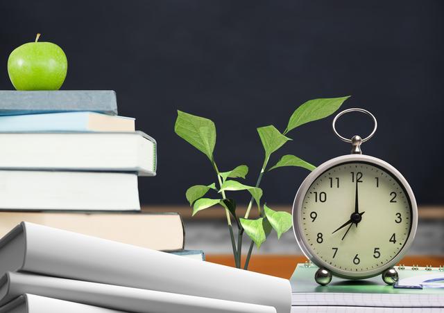 Close-up image showcasing a classroom setting with essential items including stacks of books, an alarm clock, and a green apple. This composition is perfect for illustrating themes related to education, studying, school environments, academic scheduling, and teacher resources. Suitable for educational content, school-related blog posts, and promotional materials for academic institutions or libraries.