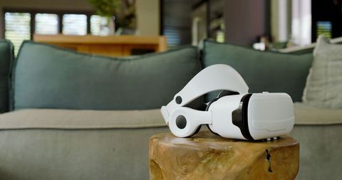 Virtual reality headset on stylish wooden table in cozy living room