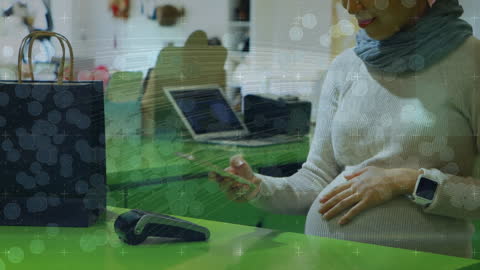 Pregnant Woman Using Smartphone with Shopping Bag on Counter