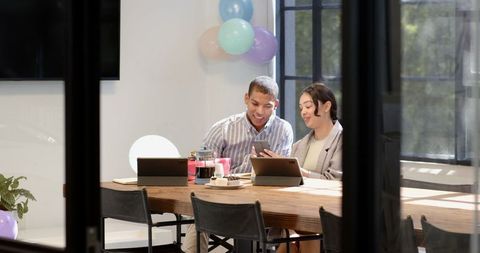 Cheerful colleagues taking selfie during office celebration