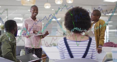 Diverse team analyzing financial graphs in modern office meeting