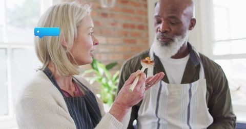 Mature Couple Sampling Meal in Cozy Modern Kitchen