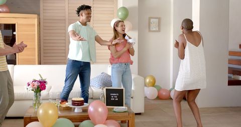 Celebrating new job with friends, cake, and balloons at home