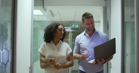 Colleagues Collaborating in Modern Office Corridor