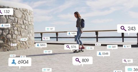 Skateboarding woman riding longboard along seaside promenade with social notifications