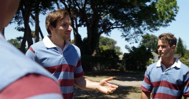 Young Men Engaging in Outdoor Rugby Discussion - Download Free Stock Images Pikwizard.com