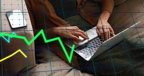 Woman typing on sofa with laptop and finance charts overlay for remote work productivity