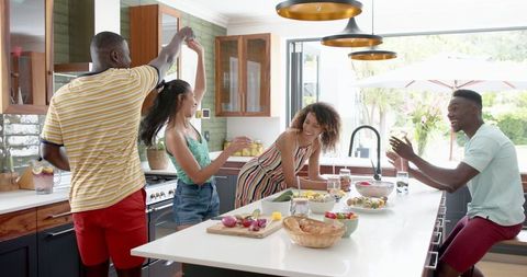 Diverse Friends Dancing in Vibrant Kitchen Gathering