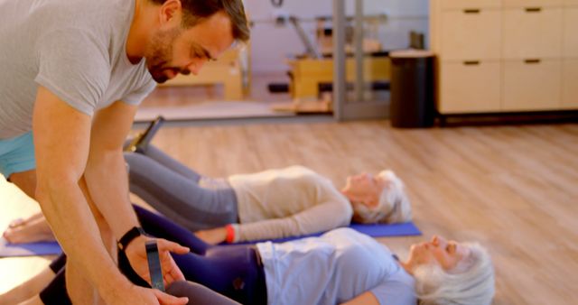 Senior women doing yoga exercises with instructor in fitness studio - Download Free Stock Images Pikwizard.com