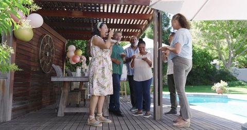 Diverse Seniors Celebrating Over Drinks by Pool