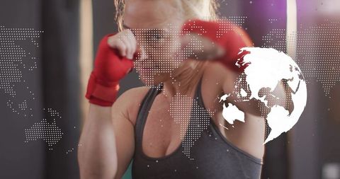 Mid-adult female boxer throwing powerful punch with world map overlay for fitness tech