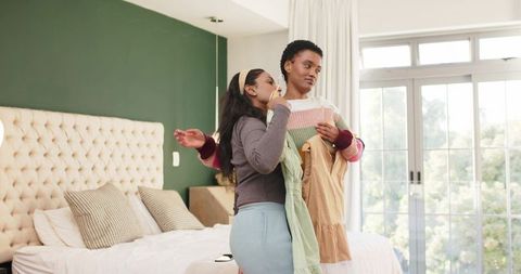 Diverse friends selecting dresses, sharing fashion ideas